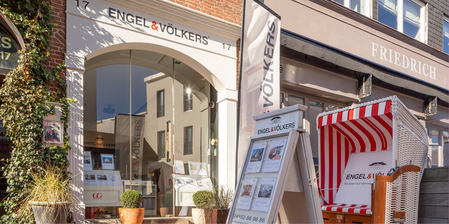 Engel & Völkers real estate office exterior with a red and white striped beach chair on the sidewalk.